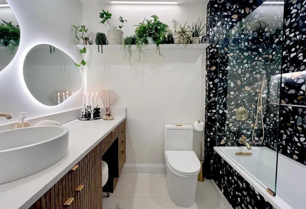 Renovated bathroom with terrazzo tile and round mirror